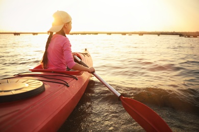 Photo of Little girl kayaking on river. Summer camp activity