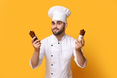 Photo of Professional chef with shakers on yellow background
