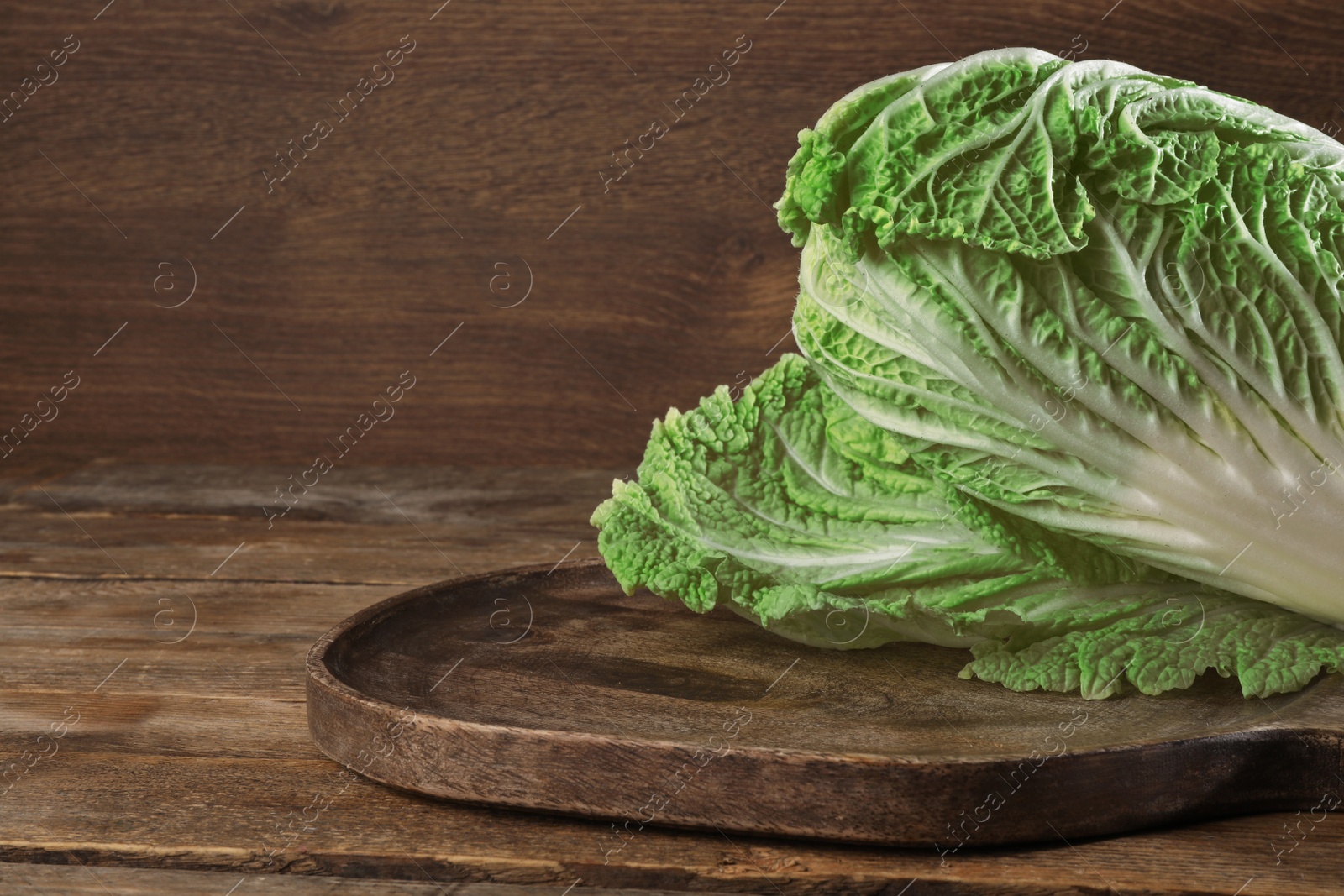 Photo of Fresh ripe Chinese cabbage on wooden table. Space for text