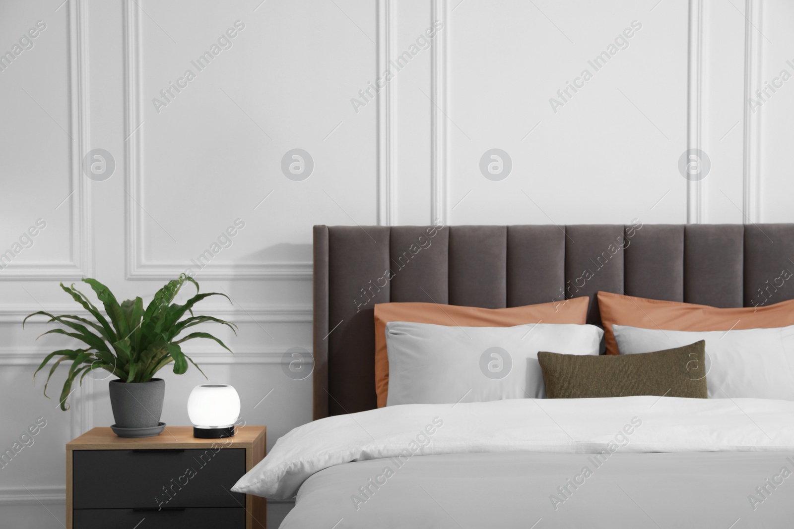 Photo of Stylish bedroom interior with large comfortable bed and table