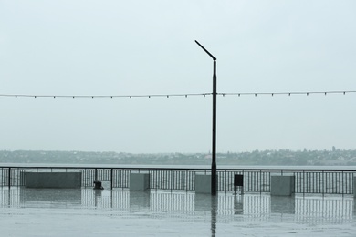 Photo of Empty city embankment on grey rainy day