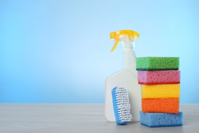 Photo of Bottle of cleaning product and supplies on light table. Space for text