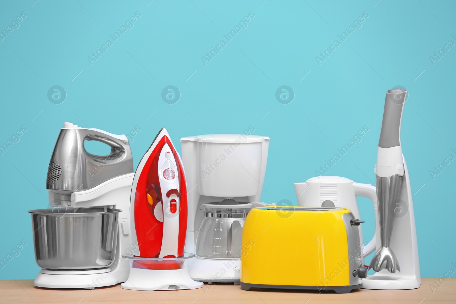 Photo of Household and kitchen appliances on table against color background. Interior element