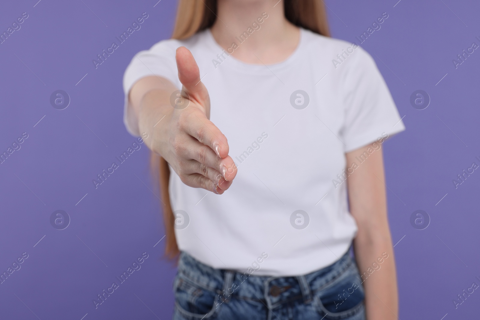 Photo of Woman welcoming and offering handshake on purple background, closeup