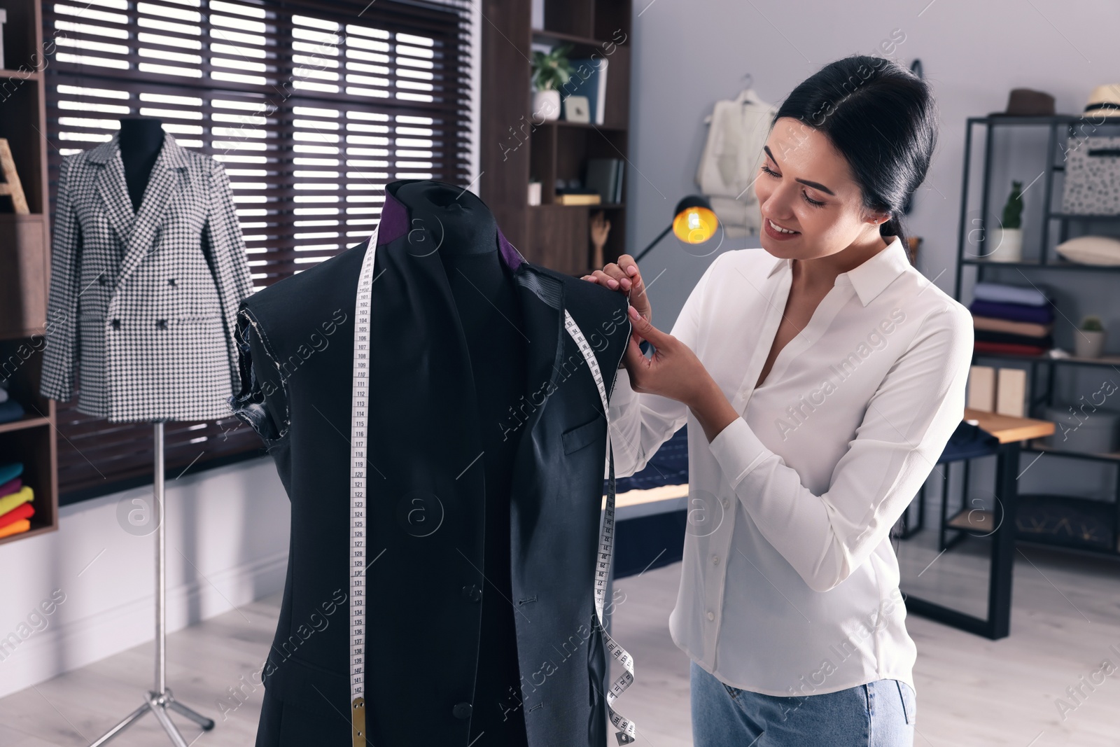 Photo of Professional dressmaker making suit jacket in atelier