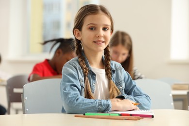 Photo of Portrait of smiling little girl studying in classroom at school