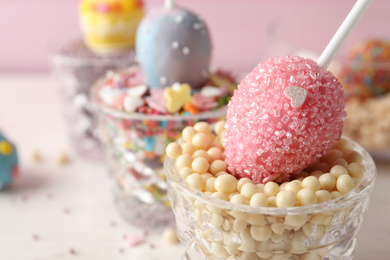 Photo of Egg shaped cake pop on table, closeup with space for text. Easter celebration
