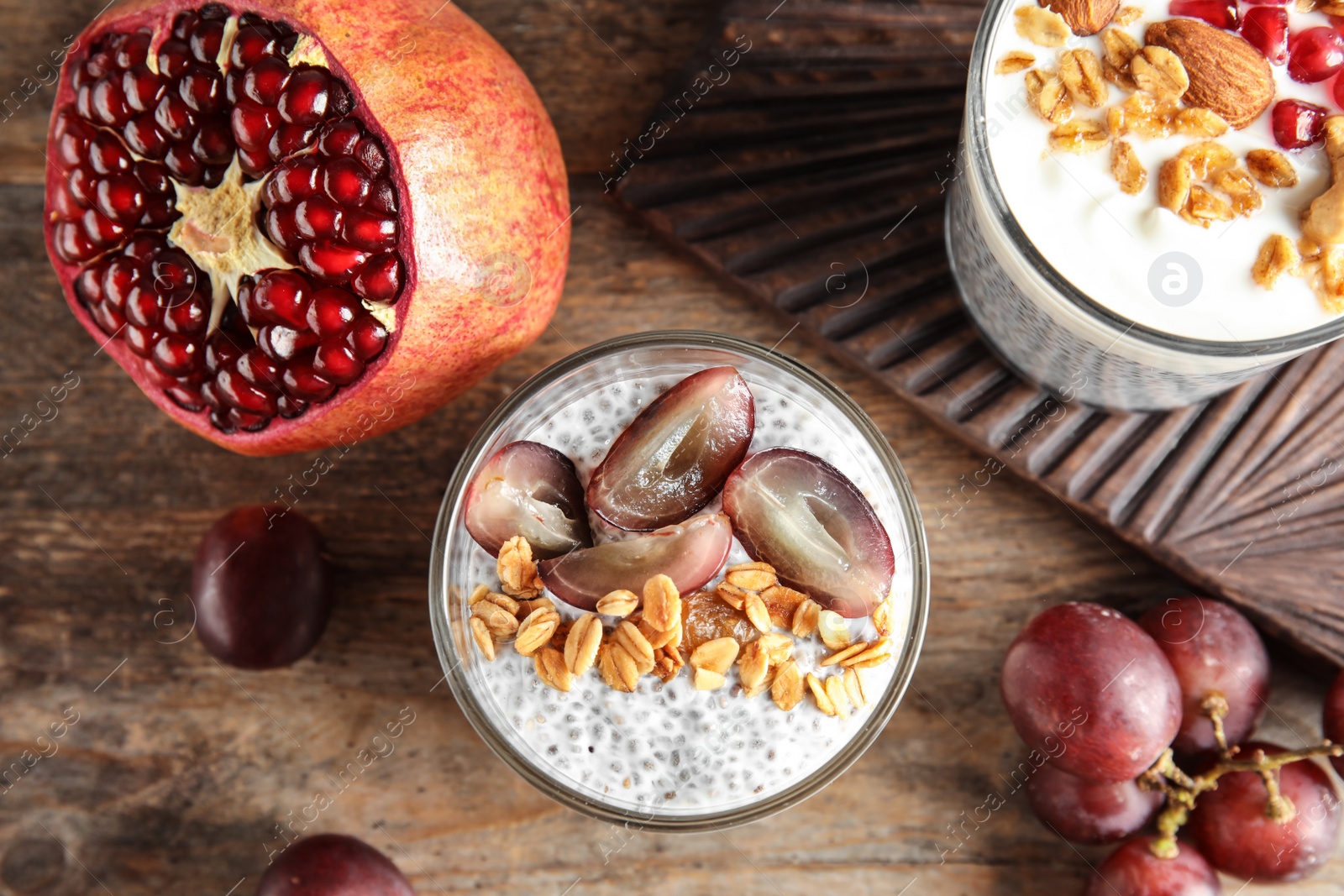 Photo of Tasty chia seed pudding with granola and ingredients on table, flat lay