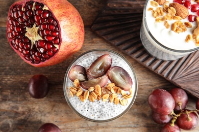 Tasty chia seed pudding with granola and ingredients on table, flat lay