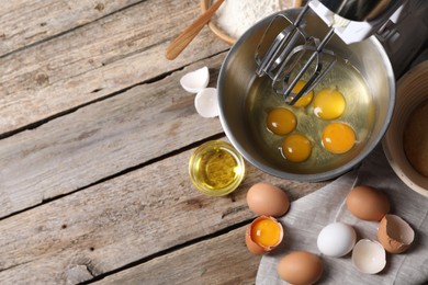 Making dough. Raw eggs in bowl of stand mixer and ingredients on wooden table, flat lay with space for text