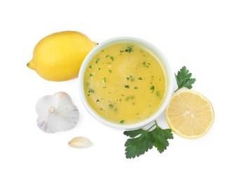 Photo of Bowl with lemon sauce and ingredients on white background, top view. Delicious salad dressing