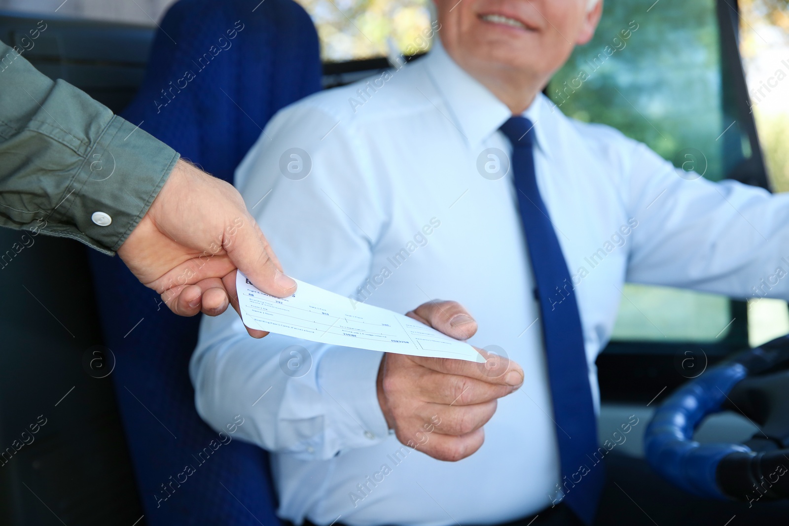 Photo of Professional driver taking ticket from passenger in bus