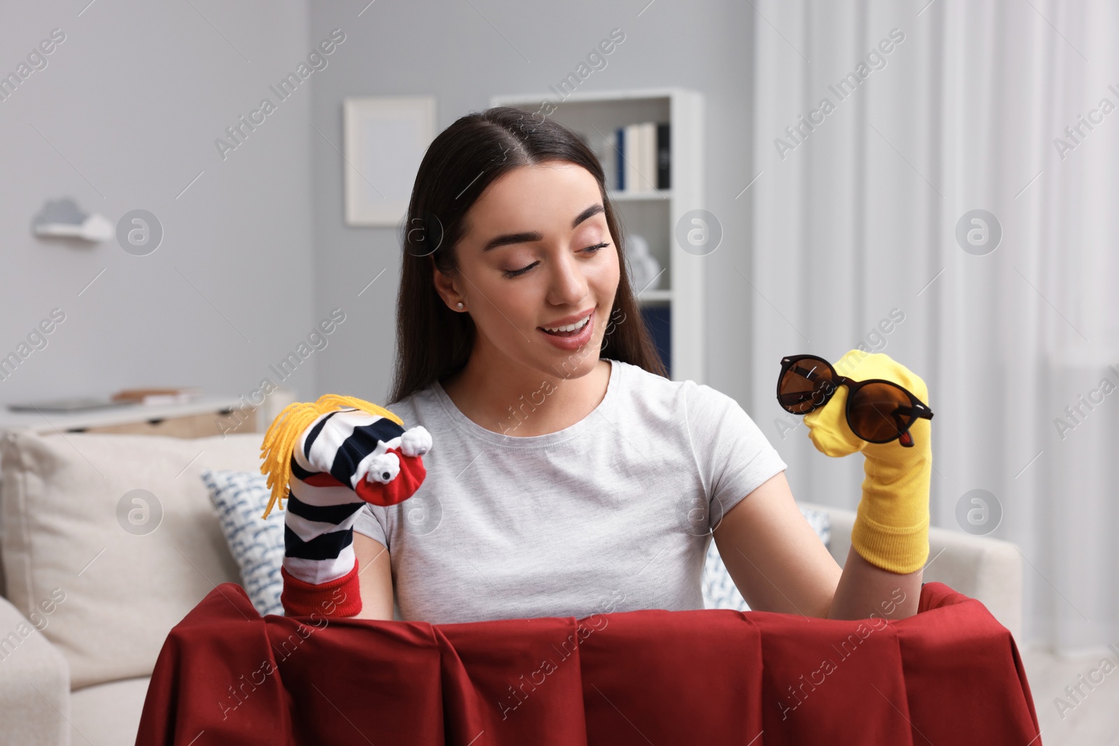 Photo of Happy woman performing puppet show at home