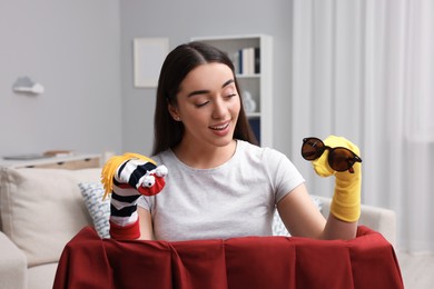 Photo of Happy woman performing puppet show at home