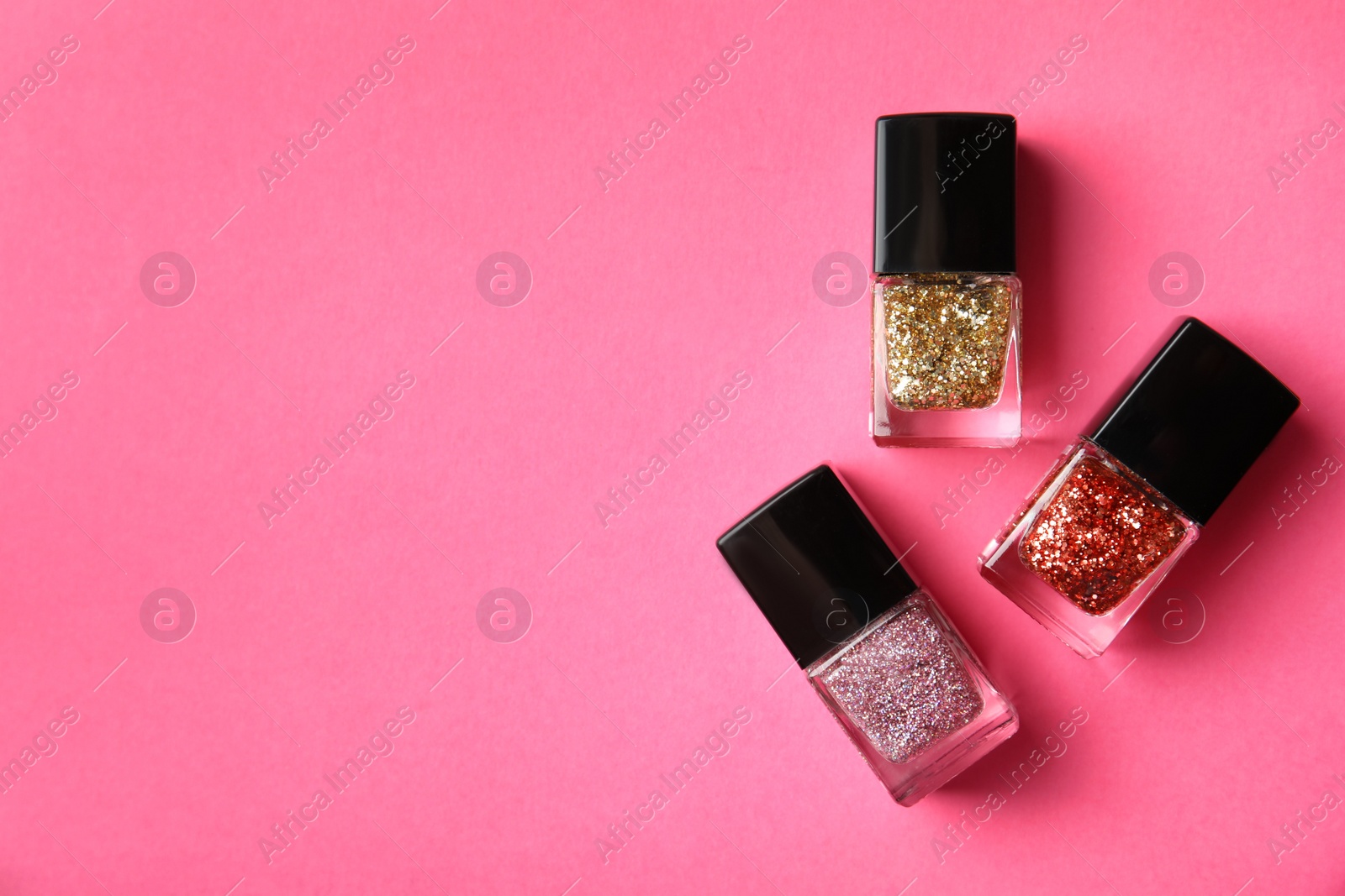 Photo of Bottles of nail polish on color background, top view with space for text