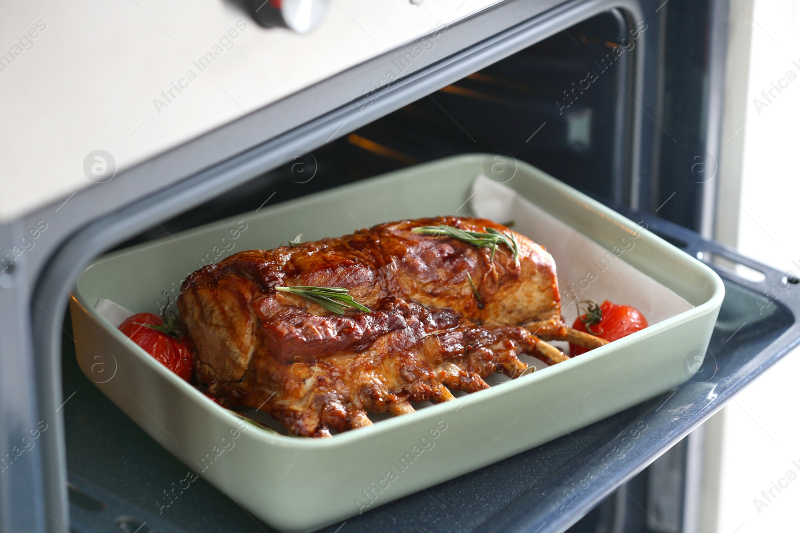 Photo of Delicious roasted ribs with tomatoes in oven