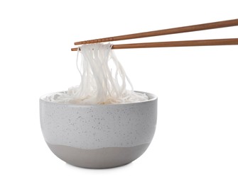 Photo of Chopsticks with cooked rice noodles over bowl isolated on white