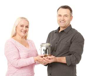 Happy senior man and his wife holding jar with coins on white background