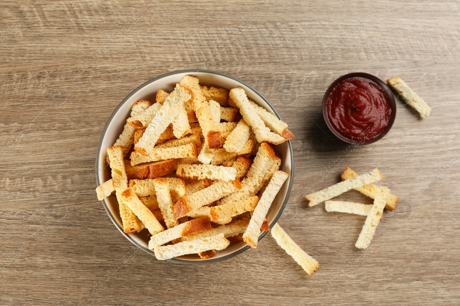 Photo of Delicious hard chucks with ketchup on wooden table, flat lay