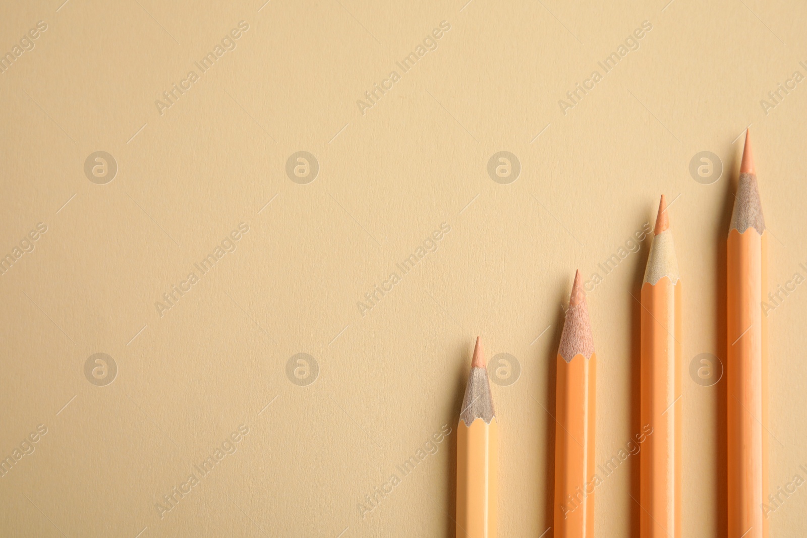 Photo of Flat lay composition with color pencils on beige background. Space for text