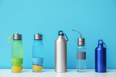 Different water bottles for sports on color background