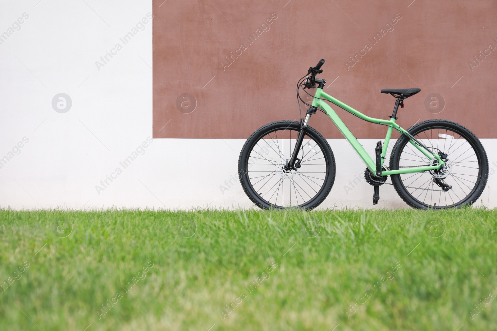 Photo of New modern color bicycle near color wall outdoors
