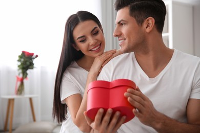 Lovely couple with gift box at home. Valentine's day celebration