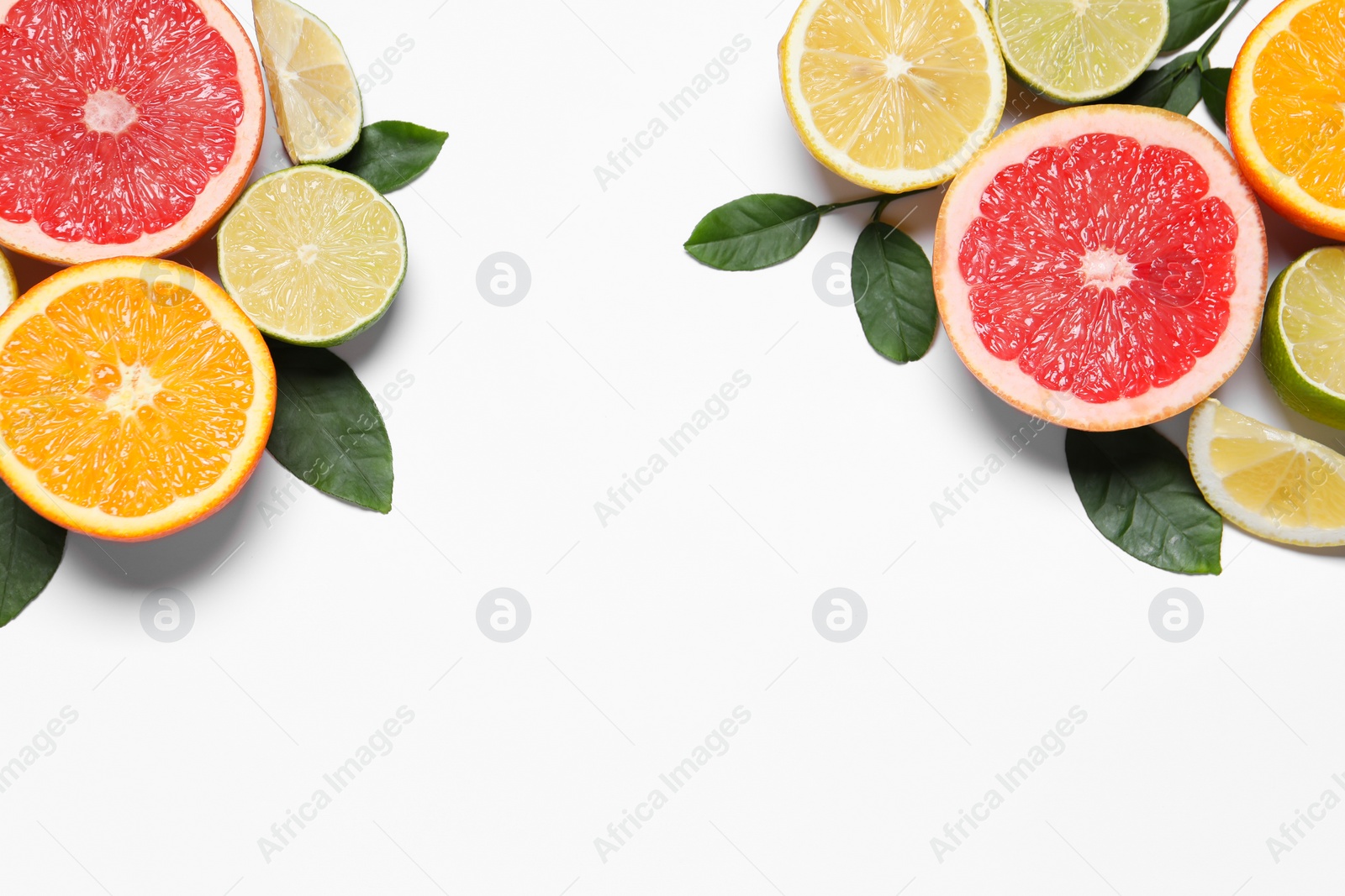 Photo of Different cut citrus fruits and leaves on white table, flat lay. Space for text