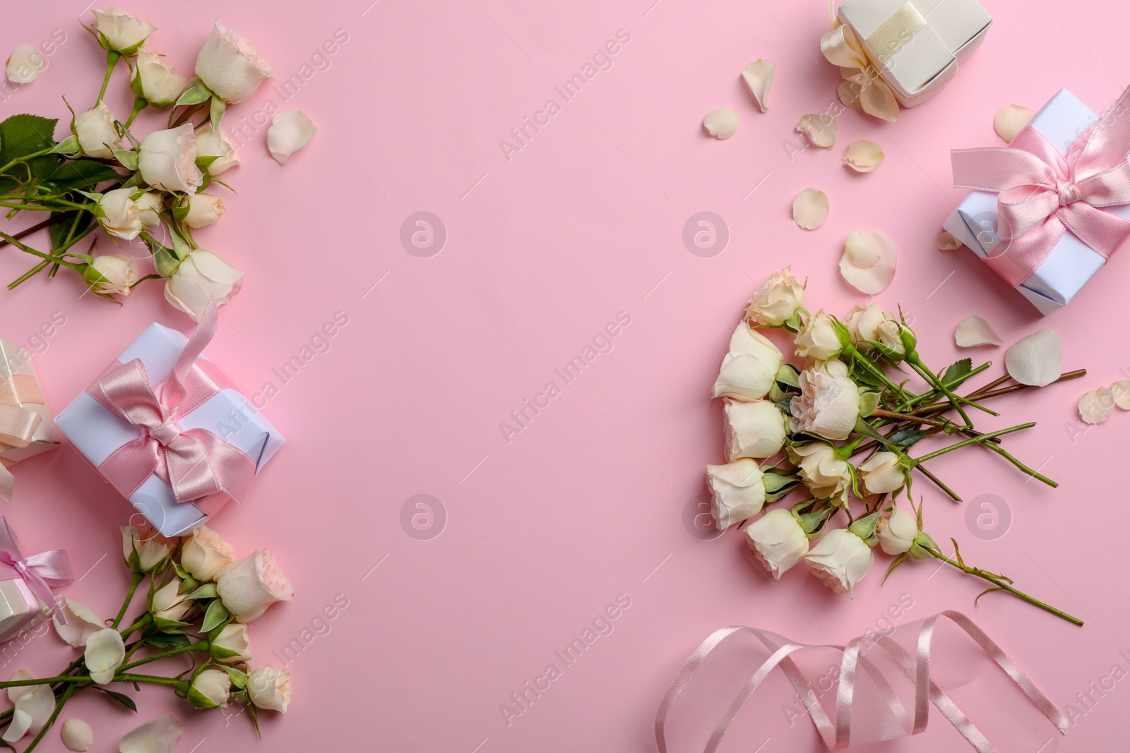 Photo of Flat lay composition with beautiful roses and gift boxes on color background. Space for text