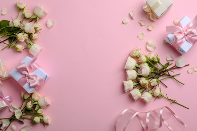 Photo of Flat lay composition with beautiful roses and gift boxes on color background. Space for text