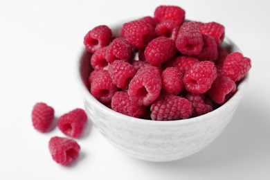 Photo of Bowl of delicious ripe raspberries on white background