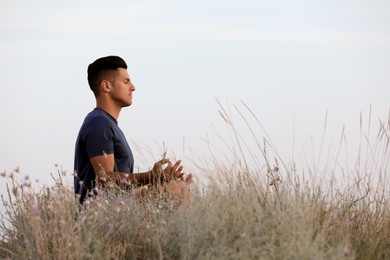 Photo of Man meditating on hill, space for text