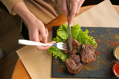 Photo of Woman eating tasty shish kebab in cafe