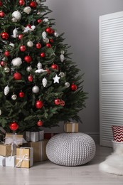 Photo of Beautifully decorated Christmas tree and many gift boxes in room