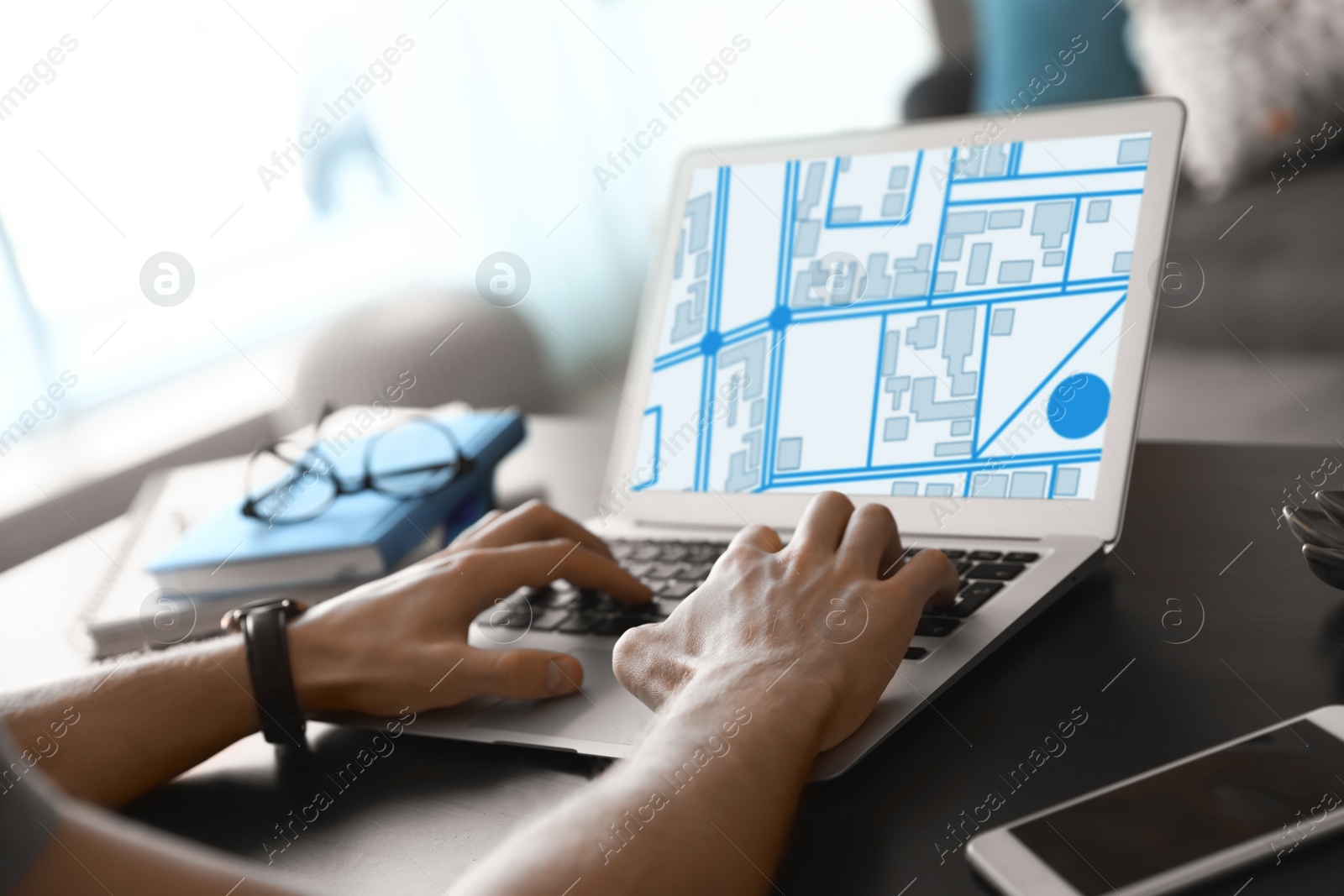 Image of Man analyzing cadastral map on laptop at table, closeup 