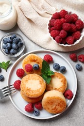 Delicious cottage cheese pancakes with berries on light table, flat lay