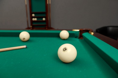 Photo of Billiard balls and cue on table indoors