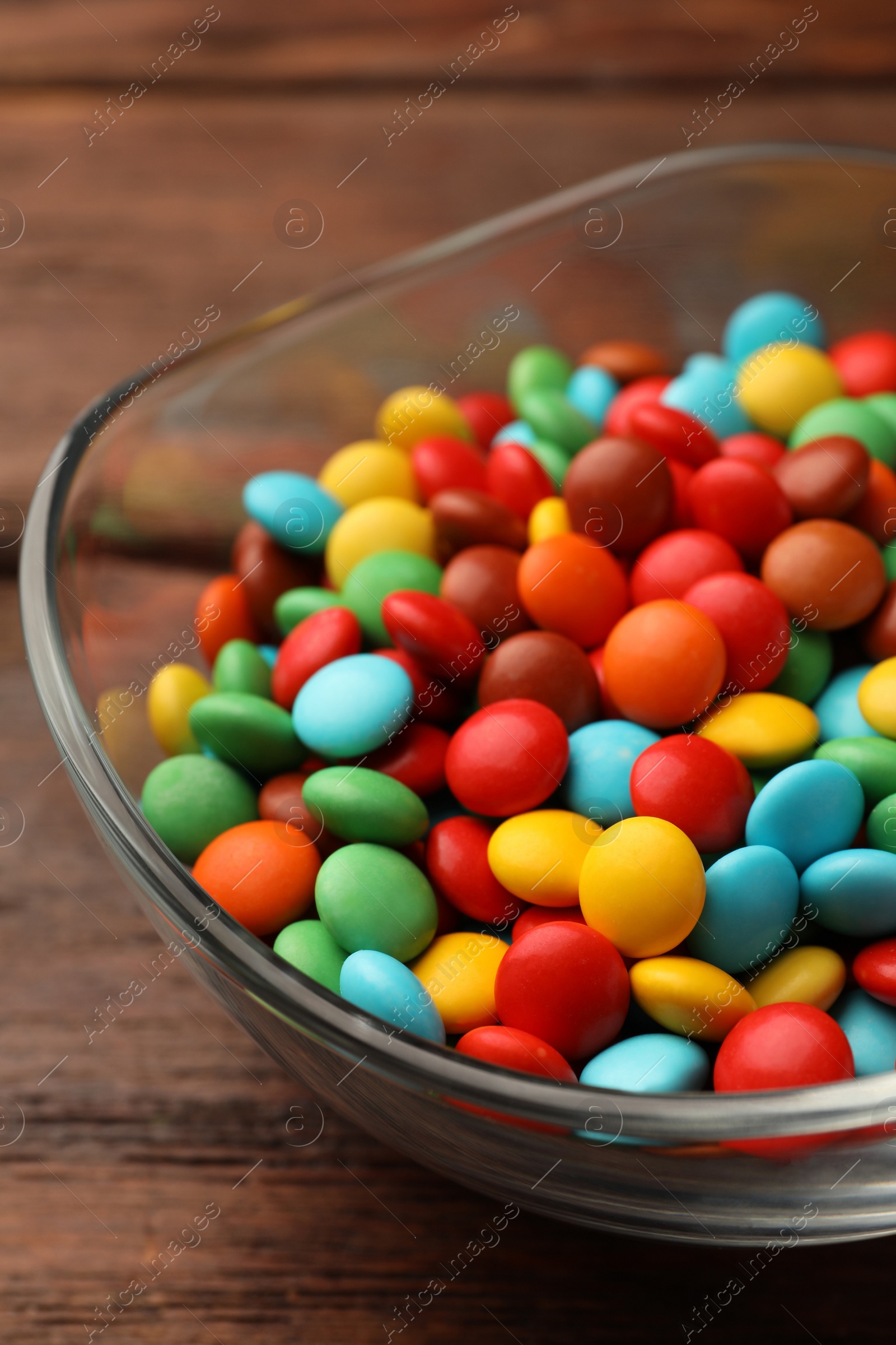 Photo of Tasty colorful candies on wooden table, closeup