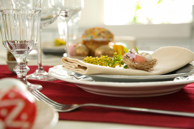 Photo of Festive Easter table setting with floral decor, closeup