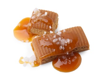 Yummy caramel candies and sea salt isolated on white