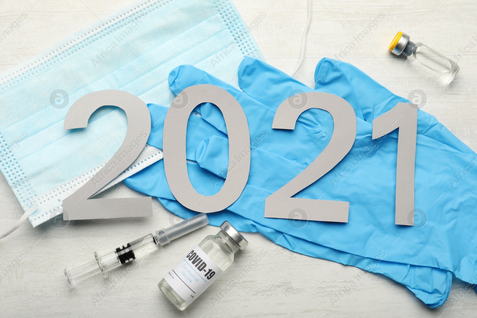 Photo of Flat lay composition with coronavirus vaccine and number 2021 on white background