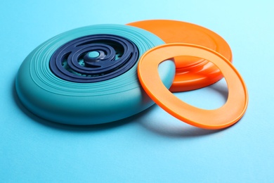 Photo of Plastic frisbee disks and ring on light blue background