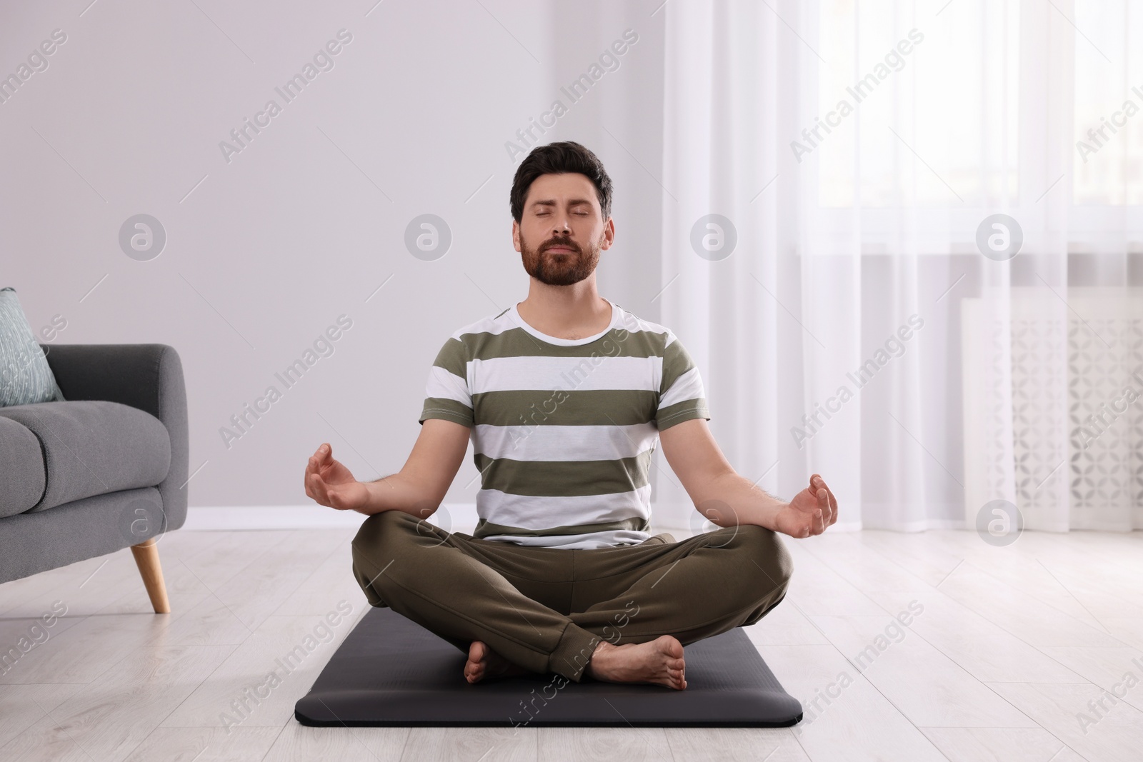 Photo of Man meditating at home. Harmony and zen