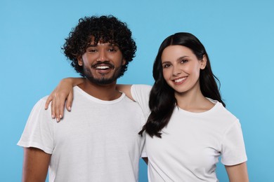 International dating. Portrait of happy couple on light blue background