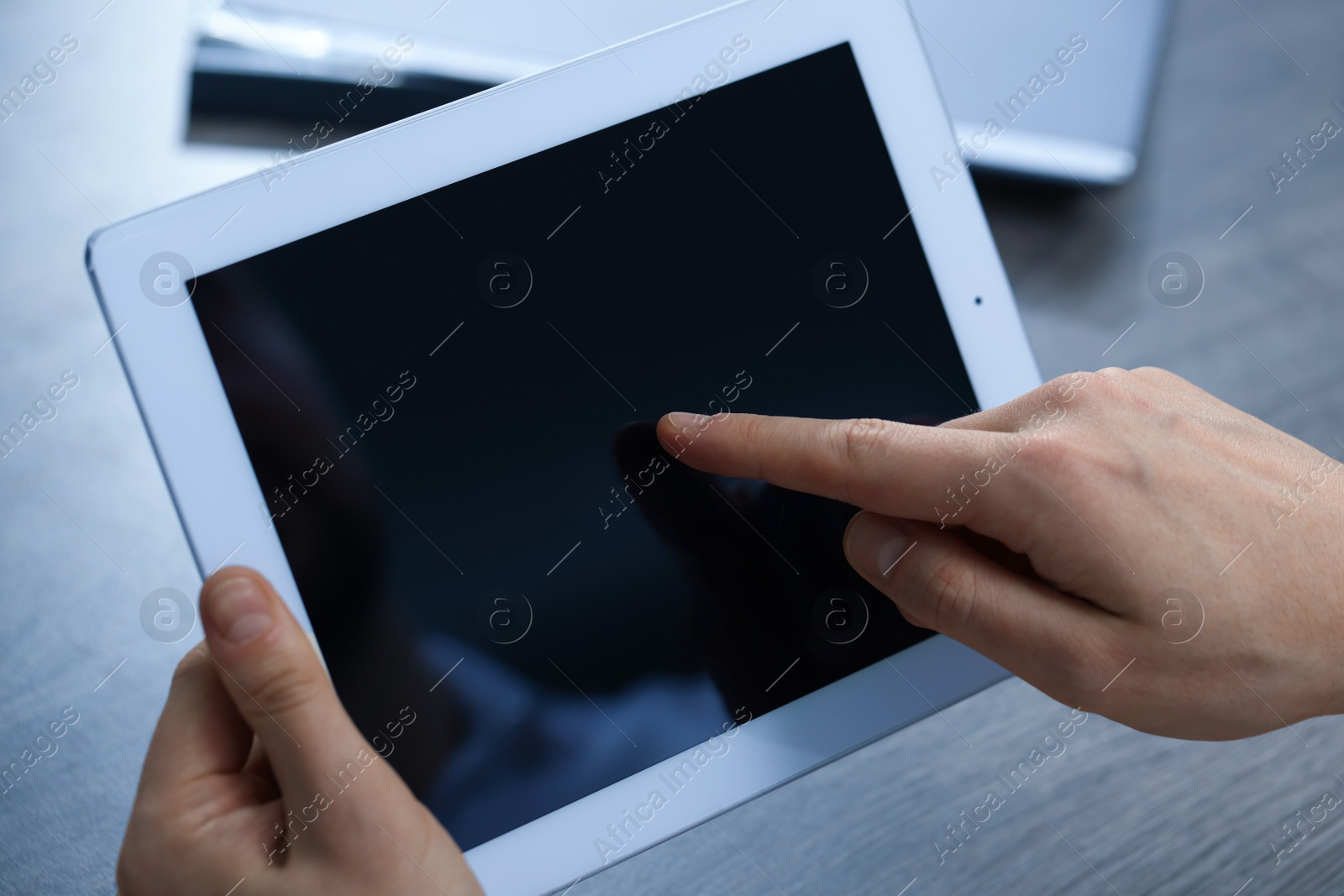 Photo of Man using tablet at wooden table, closeup