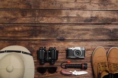 Flat lay composition with safari accessories on wooden background, space for text