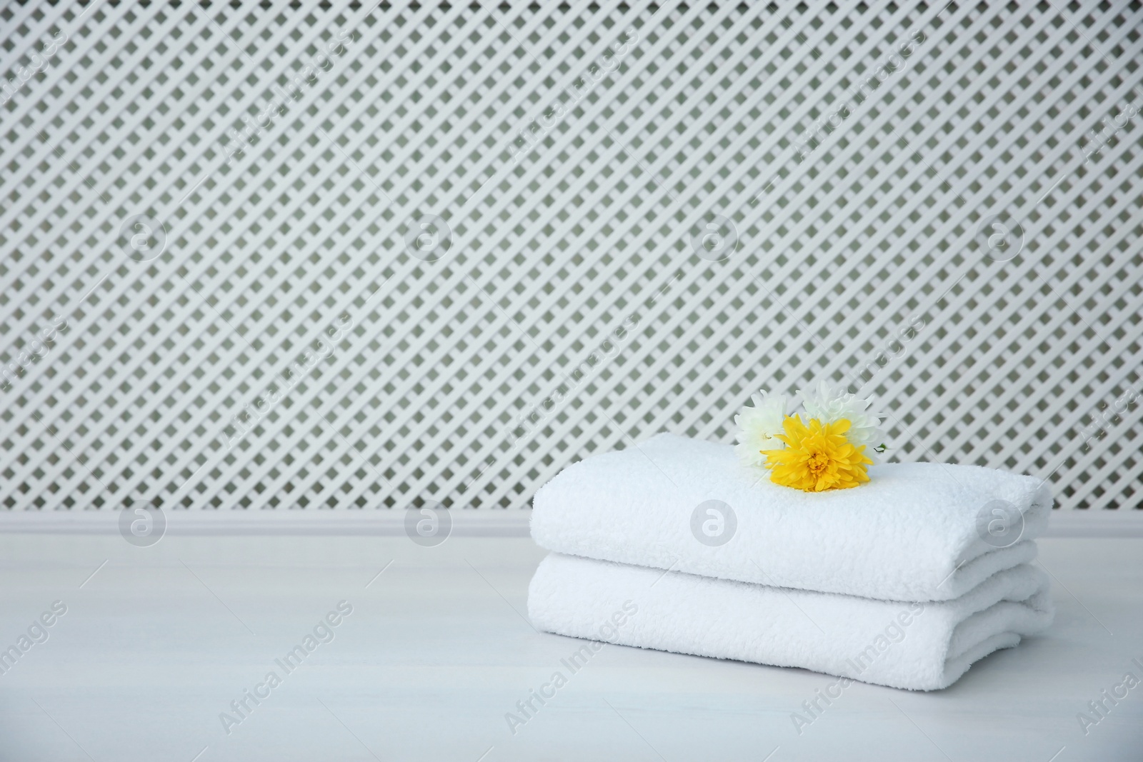 Photo of Stack of towels on table against light background