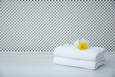 Stack of towels on table against light background
