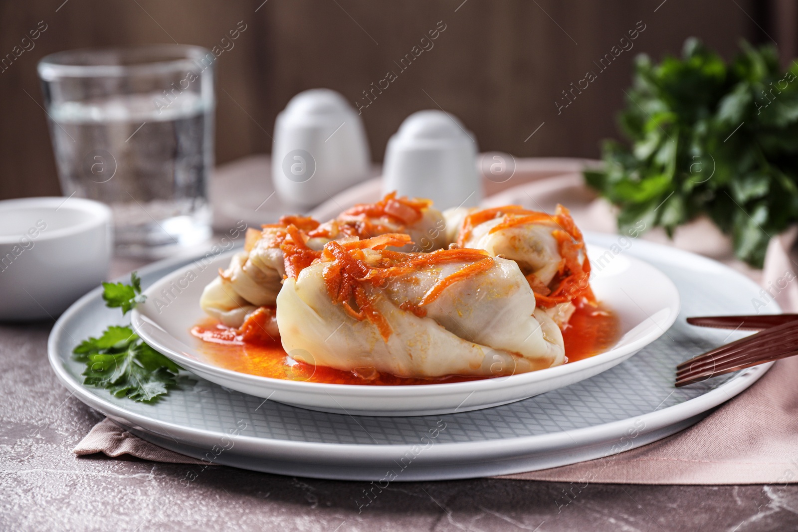 Photo of Delicious cabbage rolls served on grey marble table