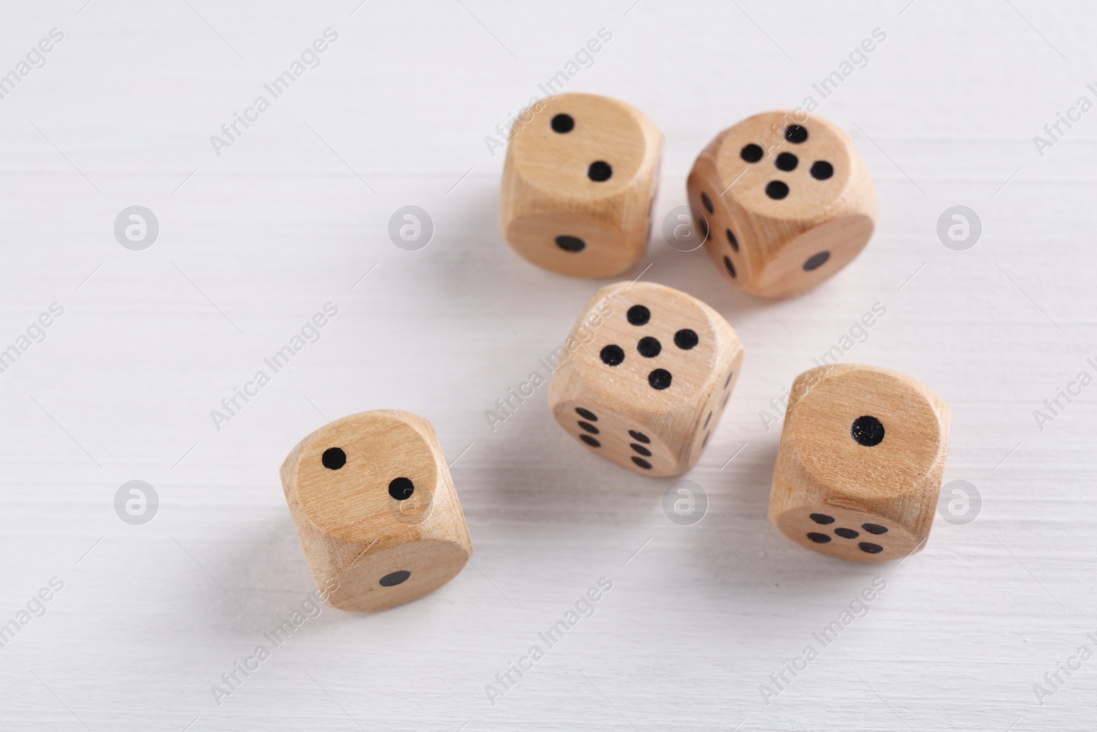 Photo of Many game dices on white wooden table, above view. Space for text